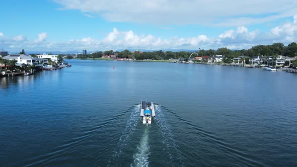 Small boat deliverers a large pontoon to a luxury waterfront property on a city canal. High drone vi