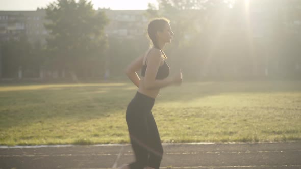 Slim Caucasian Woman Launching App on Smart Watch and Start Running. Side View Portrait of Confident