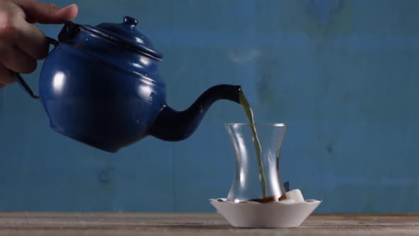 Pouring Tea From a Kettle in a Cup