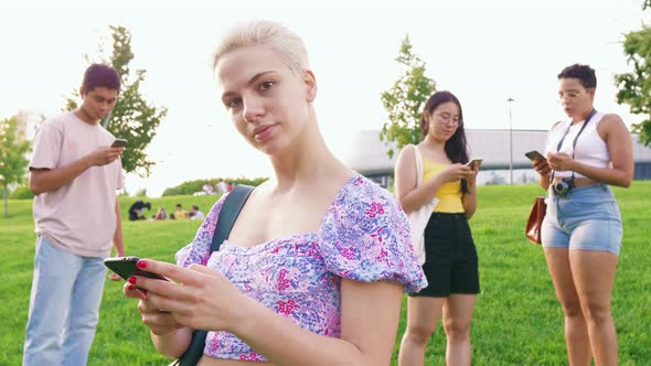 Young happy caucasiatic woman outdoor using smartphone