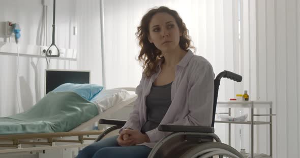 Woman Patient Feeling Depressed and Frustrated Sitting in Wheelchair in Hospital