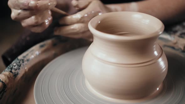 Man Potter Working on Potters Wheel Making Ceramic Pot From Clay in Pottery Workshop