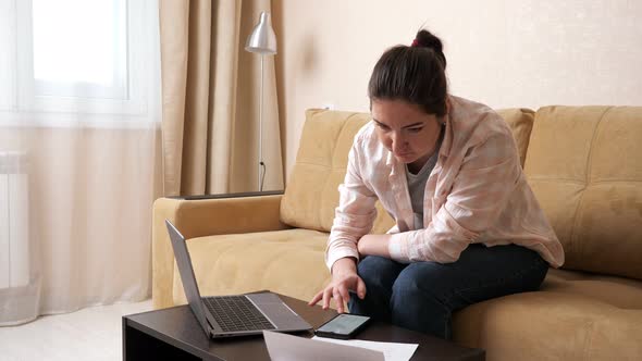 Upset Woman Tries to Calculate High Payments on Mobile Phone