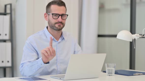 Middle Aged Man with Laptop Showing No Sign By Finger