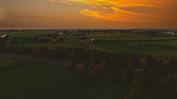 Aerial View of Corn Fields and Fertile Farmlands and Farms at a Golden Hour Sunset