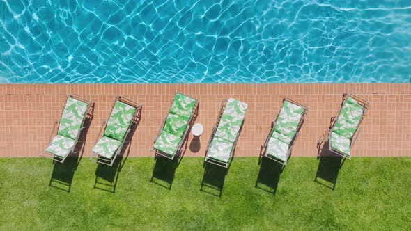 Aerial Dolly Shot Perfect Blue Swimming Pool with Sun Reflecting on Water