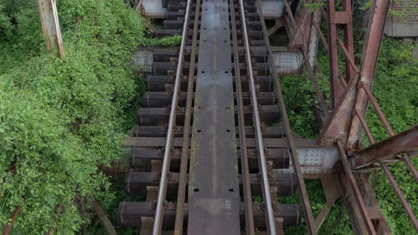 Flying backwards above the railroad track 4K drone video