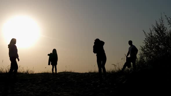 Family of Three Photographed at Sunset By the Sea