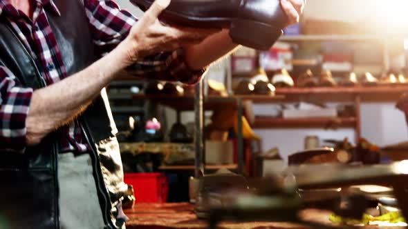 Shoemaker examining a shoe