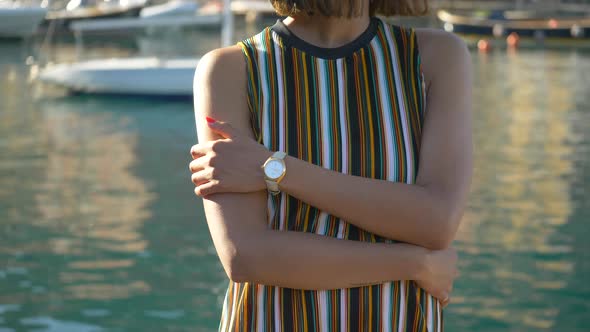 A woman with watch, hat, sunglasses, striped dress traveling, Portofino, Italy, luxury resort Europe