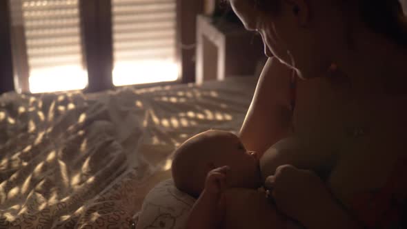 Mother Breastfeeding Baby in Bedroom