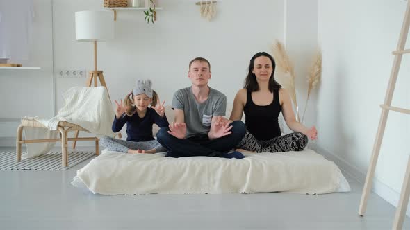 Family Meditating While Sitting in Lotus Position