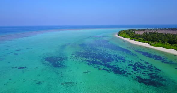 Wide angle fly over abstract shot of a white paradise beach and blue ocean background in hi res 4K