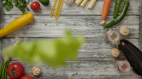 Crop People Dropping Down Lettuce Sheets on Wooden Table