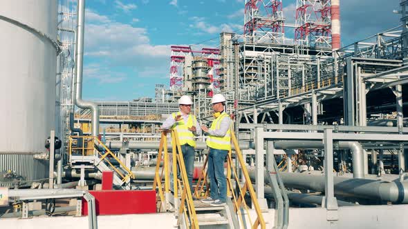 Workers are Planning a Project on the Premises of the Oil Refinery