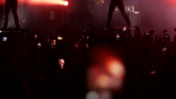 Energetic People Dancing with Their Hands Up at the Punk Concert - Bright Lights