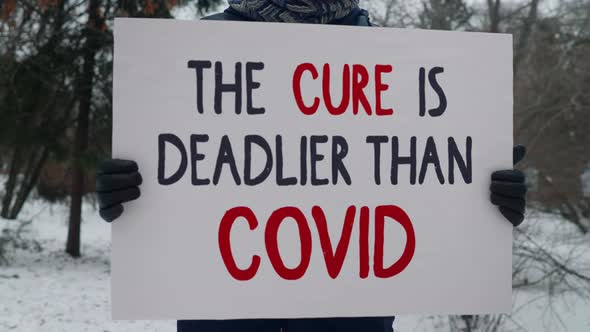 Person Holds a Sign that says The Cure is Deadlier than Covid. Vaccine Refusal