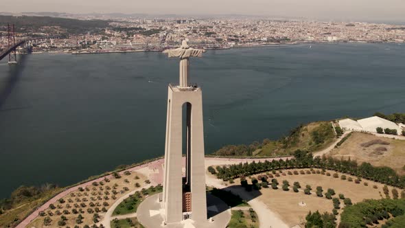 Aerial dolly in shot of pedestal monument, Sanctuary of Christ the King in Almada facing Lisbon.