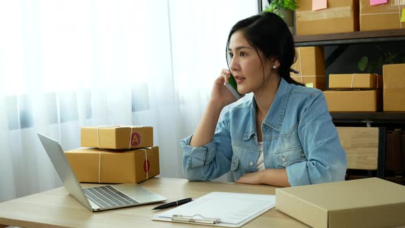 Online seller entrepreneur young asian woman using phone calling, checking order