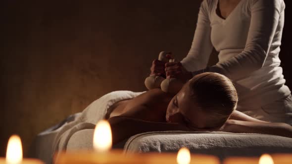 Young, healthy and beautiful woman gets massage therapy in the spa salon.