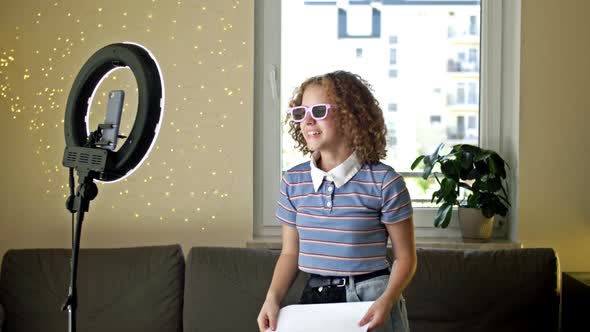 Cheerful Girl Blogger Shows a Poster with 1 Million Subscribers to the Camera