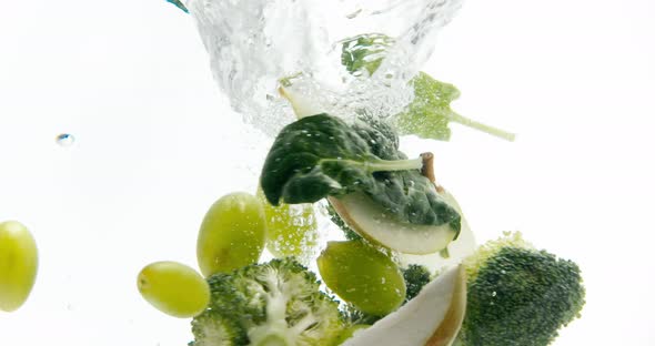 Green Fruits and Vegetables Fall Into the Whirlpool of Water and Whirl