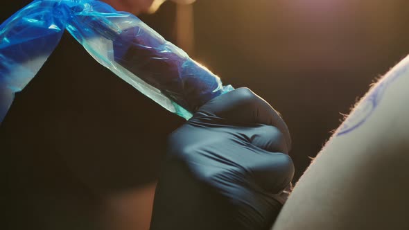 Close Shot of Working Tattoo Machine Covered in Plastic Sheet for Protection