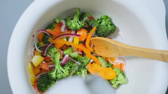 Vegan Pours Oil Into Fresh Vegetables Salad in Bowl Macro