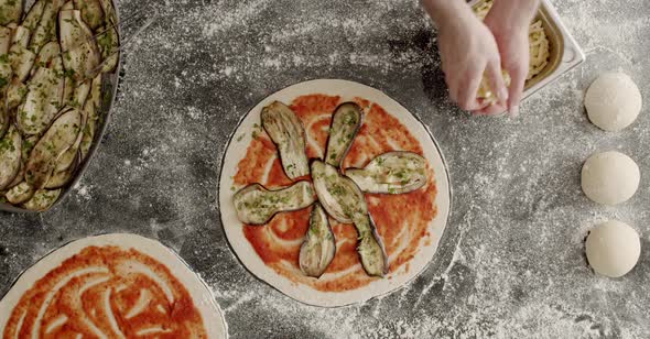 Anonymous man adding cheese to pizza