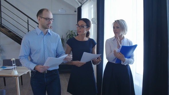 Confident business partners walking down in office building