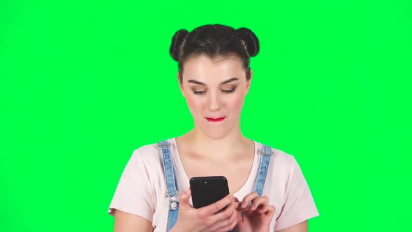 Portrait of Smiling Girl Talking for Mobile Phone and Rejoice on Green Screen, Slow Motion