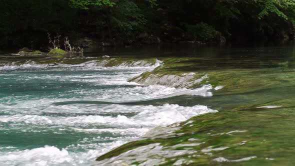 Threshold is Located on a Small Mountain River with Biue Water Flows Between the Stones