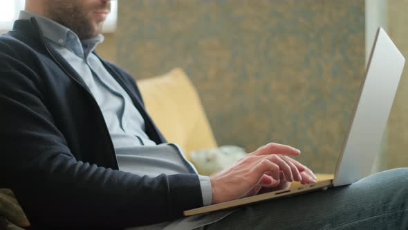 Remote Job. A Man Is Working with Documents on Laptop Remotely at Home. A Business Man Is Using