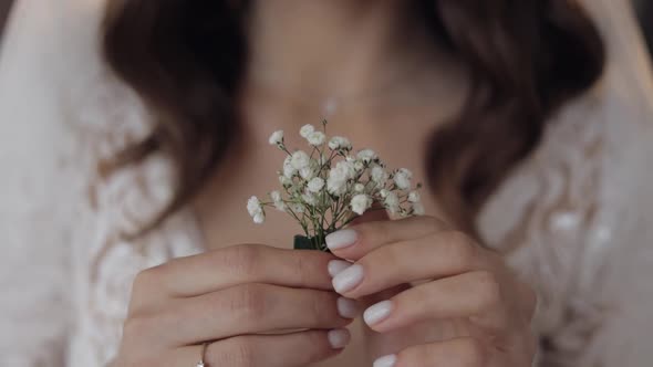 Closeup of Beautiful Lovely Stylish Smiling Bride Girl Looking at Gypsophila Flower Bouquet at Home