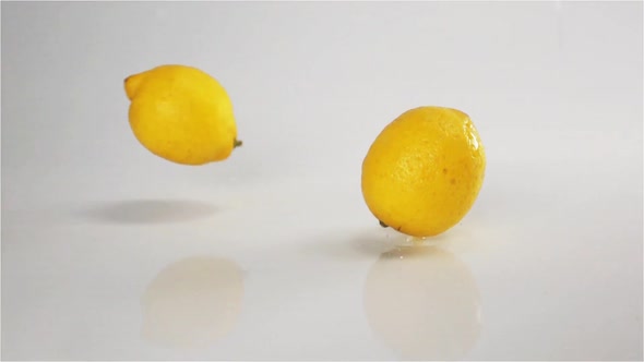 Lemons Fall Down at White Wet Surface