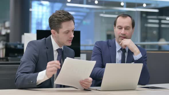 Businessman Working with Colleague in Office