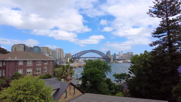 Tracking shot of Sydney Harbour Bridge with houses in the foreground