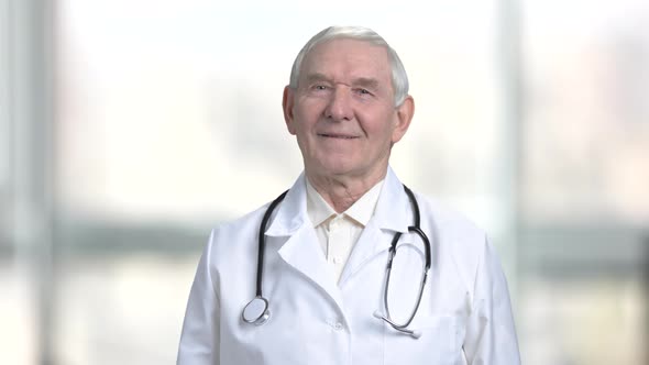 Portrait of Senior Doctor in Abstract Blurred Bright Background.