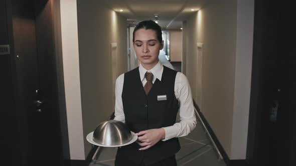 Waitress Walking along Hotel Corridor with Serving Tray