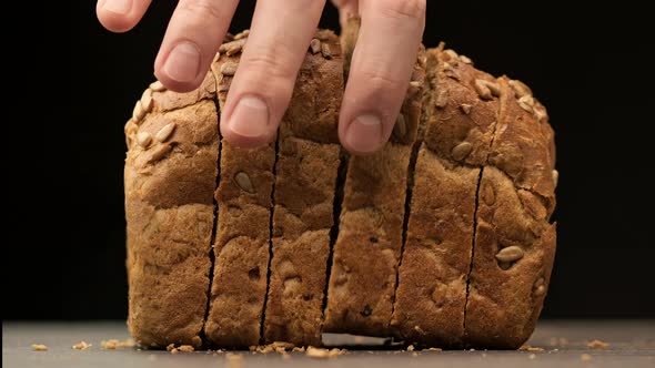 Man Takes One Slice of Cutted Bread. Close-up View of Brown Organic Bread