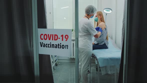 Female Doctor Making Vaccination Against Coronavirus in District Hospital