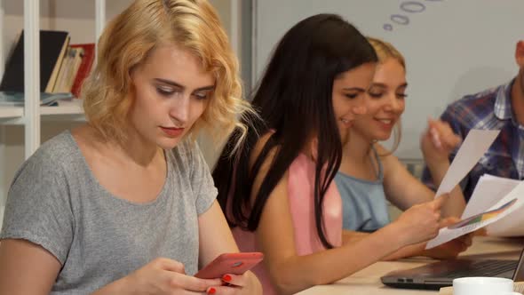 Young Businesswoman Using Her Smart Phone During Meeting