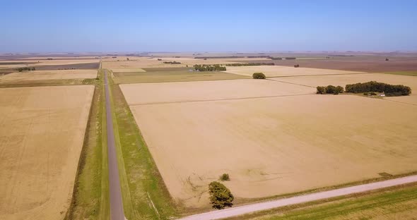 Aerial View Of Highway Road Through Wheat Fields Landscape - drone shot