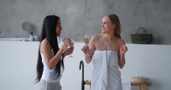 Two Cheerful Charming Beautiful Multiethnic Young Women Resting Together at Henparty in Home