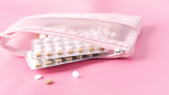 Birth Control Pills on Pink Background Close Up