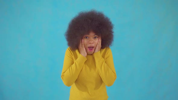 Joyful Emotional African Woman with an Afro Hairstyle in a Yellow Jacket