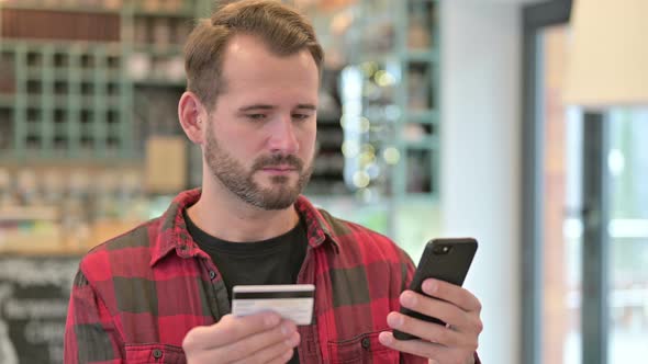 Portrait of Online Payment on Smartphone By Young Man 