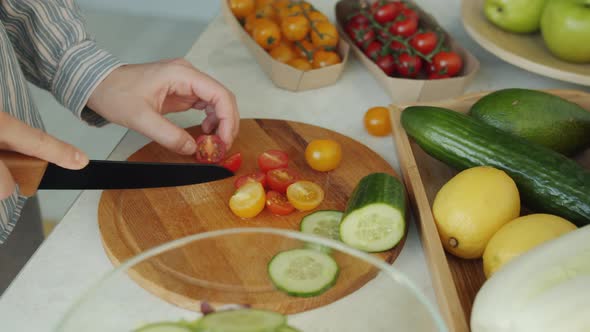 Closeup of Woman's Hands Cutting Tomatoes with Knife Cooking Lunch at Home