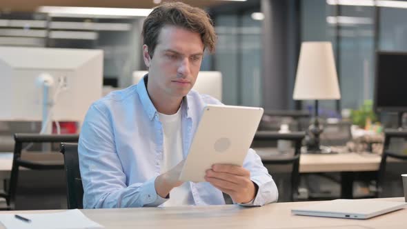 Man Using Tablet While Sitting in Office