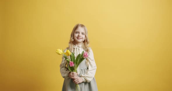 Beautiful Girl Holds Tulip Flowers in Her Hand She Smiles on Yellow Background